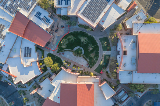 Aerial view of Sports Town USA featuring red rooftops solar panels and a central circular courtyard with landscaping in Las Vegas Nevada United States. Aerial view of Sports Town USA featuring red rooftops solar panels and a central circular courtyard with landscaping in Las Vegas Nevada United States.