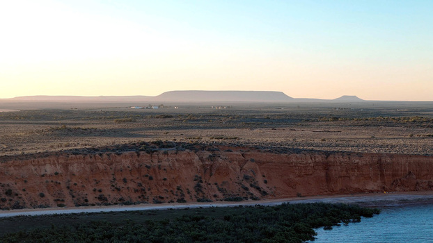 Aerial view of the Matthew Flinders Red Cliff Lookout featuring red sandstone cliffs desert vegetation and calm waters at golden hour in Port Augusta West South Australia Australia. Aerial view of the Matthew Flinders Red Cliff Lookout featuring red sandstone cliffs desert vegetation and calm waters at golden hour in Port Augusta West South Australia Australia.