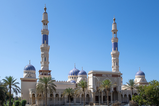 View of the Mohammed Al Ameen Mosque with its prominent blue domes and tall minarets set against a clear blue sky in Muscat Muscat Governorate Oman. View of the Mohammed Al Ameen Mosque with its prominent blue domes and tall minarets set against a clear blue sky in Muscat Muscat Governorate Oman.
