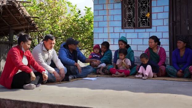 View of a group of people sitting outside a house in Surkhet Nepal.