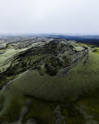 Aerial view of a rugged moss covered landscape reveals a tapestry of textures beneath a blanket of overcast skies Lakagigar Iceland. Aerial view of a rugged moss covered landscape reveals a tapestry of textures beneath a blanket of overcast skies Lakagigar Iceland.