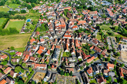 Aerial view of the historic town center of Neunkirchen am Brand with its traditional red roofed houses church tower and green gardens in Neunkirchen am Brand Bavaria Germany. Aerial view of the historic town center of Neunkirchen am Brand with its traditional red roofed houses church tower and green gardens in Neunkirchen am Brand Bavaria Germany.