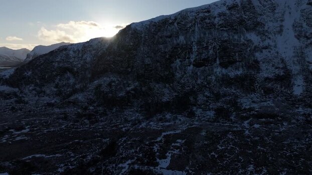 Aerial view of snowy Lofoten mountains at sunset Norway.