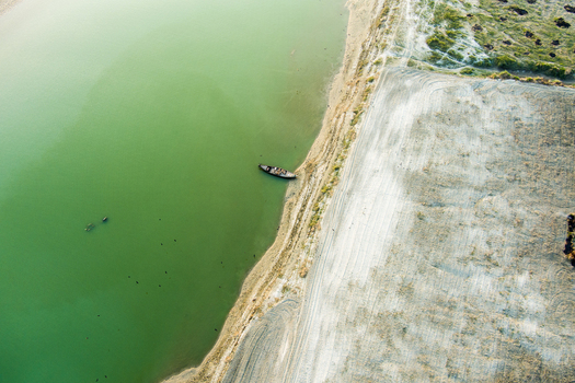 Aerial view of a small wooden boat moored on the sandy bank of the Padma River in Rajshahi Rajshahi Division Bangladesh.