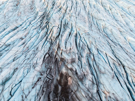 Aerial view of the deep blue crevasses and textured ice formations of Svinafellsjokull glacier in Sveitarfelagid Hornafjordur Iceland. Aerial view of the deep blue crevasses and textured ice formations of Svinafellsjokull glacier in Sveitarfelagid Hornafjordur Iceland.