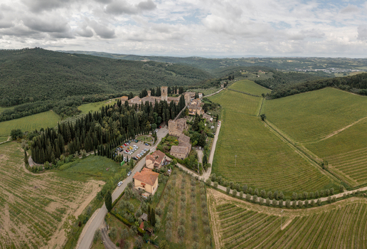 Aerial view of the historic village of Passignano surrounded by lush vineyards cypress trees and rolling hills under a cloudy sky in Passignano Toscana Italy. Aerial view of the historic village of Passignano surrounded by lush vineyards cypress trees and rolling hills under a cloudy sky in Passignano Toscana Italy.