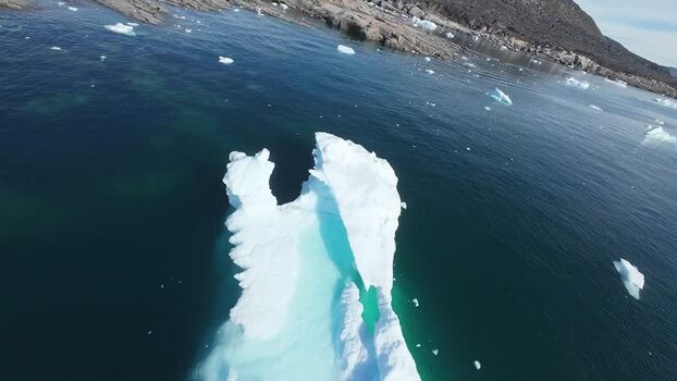 FPV aerial view of iceberg in dark blue water Greenland. FPV aerial view of iceberg in dark blue water Greenland.