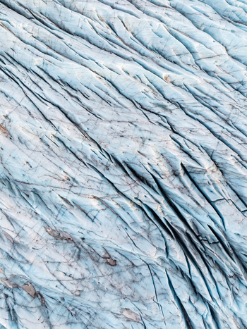 Aerial view of the deep blue crevasses and textured ice surface of Svinafellsjokull glacier in Sveitarfelagid Hornaf Iceland. Aerial view of the deep blue crevasses and textured ice surface of Svinafellsjokull glacier in Sveitarfelagid Hornaf Iceland.