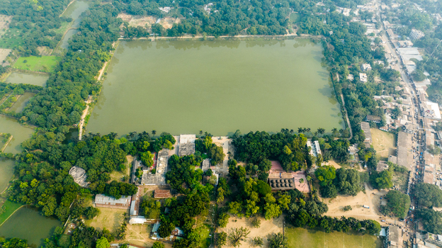 Aerial view of Bagha Shahi Mosque and its large historic pond surrounded by lush greenery and rural landscape in Rajshahi Rajshahi Division Bangladesh.