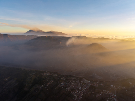 Aerial view of Cemorolawang village in the volcanic landscape of Mount Bromo at sunset with golden light over the caldera and peaks Kecamatan Sukapura Jawa Timur Indonesia.