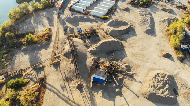 Aerial view of an industrial sand and gravel extraction site with conveyor belts piles of aggregate and storage facilities near a river in Sremska Mitrovica Vojvodina Serbia.