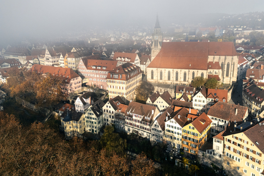 Aerial view of the historic old town with the Stiftskirche church and traditional half timbered houses under a morning mist in Tubingen Baden Wurttemberg Germany. Aerial view of the historic old town with the Stiftskirche church and traditional half timbered houses under a morning mist in Tubingen Baden Wurttemberg Germany.
