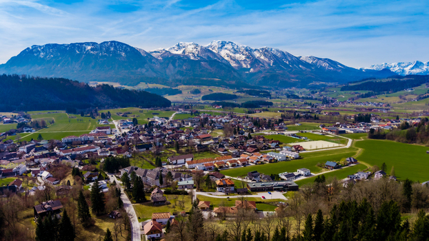 Aerial view of Windischgarsten valley nestled amid rolling hills with snow capped mountains piercing the horizon a symphony of green and white Windischgarsten Upper Austria Austria. Aerial view of Windischgarsten valley nestled amid rolling hills with snow capped mountains piercing the horizon a symphony of green and white Windischgarsten Upper Austria Austria.