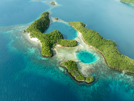 Aerial view of Bucas Grande featuring lush green islands surrounded by turquoise lagoons coral reefs and deep blue ocean waters in Siargao Philippines. Aerial view of Bucas Grande featuring lush green islands surrounded by turquoise lagoons coral reefs and deep blue ocean waters in Siargao Philippines.