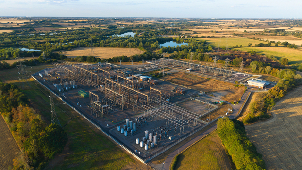 Aerial view of Grendon national grid station featuring electrical transformers power lines and infrastructure surrounded by rural fields and ponds in Northampton England United Kingdom. Aerial view of Grendon national grid station featuring electrical transformers power lines and infrastructure surrounded by rural fields and ponds in Northampton England United Kingdom.
