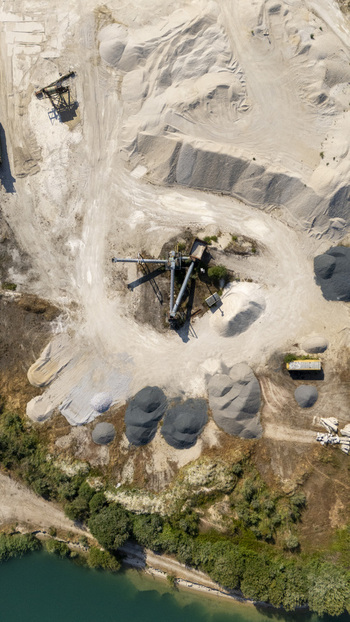 Aerial view of Extraccion de aridos Lima SL showing piles of gravel and sand industrial machinery and a nearby river in Vilarino das Poldras Ourense Spain. Aerial view of Extraccion de aridos Lima SL showing piles of gravel and sand industrial machinery and a nearby river in Vilarino das Poldras Ourense Spain.