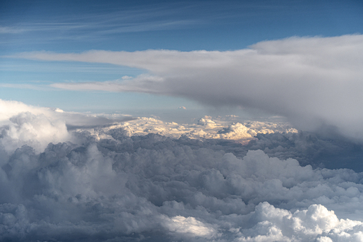 Aerial view of vast fluffy white cumulus clouds and dense formations under a clear blue sky over India. Aerial view of vast fluffy white cumulus clouds and dense formations under a clear blue sky over India.