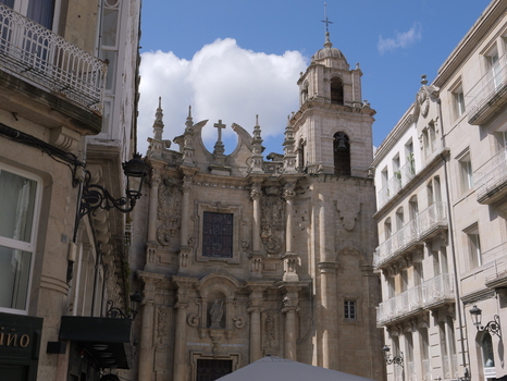 View of Igrexa da Santa Eufemia with its ornate baroque facade and bell tower framed by historic stone buildings under a blue sky in Ourense Ourense Spain.