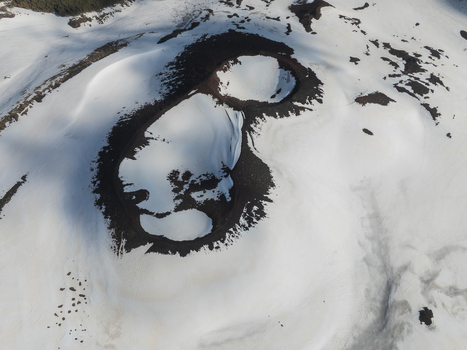 Aerial view of the snow covered volcanic craters on the Versante sud dell Etna with dark lava rock and shadows Nicolosi Sicilia Italy. Aerial view of the snow covered volcanic craters on the Versante sud dell Etna with dark lava rock and shadows Nicolosi Sicilia Italy.