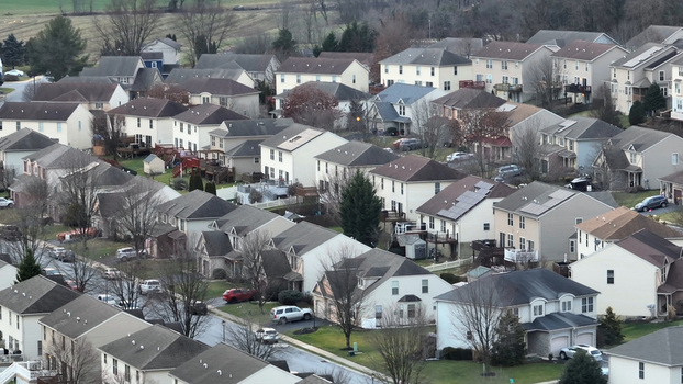 Aerial view of a residential neighborhood with suburban houses bare trees and winter light in Akron Pennsylvania United States.