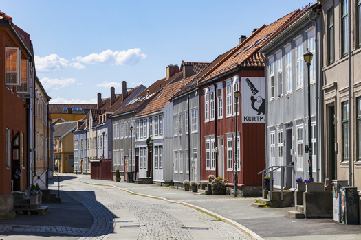 View of the quaint street lined with colorful wooden buildings under a clear blue sky evokes a sense of timeless charm Trondheim Trøndelag Norway. View of the quaint street lined with colorful wooden buildings under a clear blue sky evokes a sense of timeless charm Trondheim Trøndelag Norway.