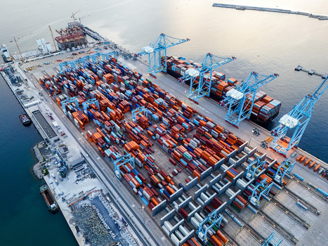 Aerial view of the semi automated container port with large cranes stacks of colorful shipping containers and a cargo ship docked at the pier in Vado Ligure Liguria Italy. Aerial view of the semi automated container port with large cranes stacks of colorful shipping containers and a cargo ship docked at the pier in Vado Ligure Liguria Italy.