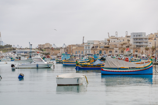 View of colorful traditional fishing boats bobbing gently on the tranquil turquoise water under a soft sky reflecting the charm of the seaside village Marsaxlokk Malta. View of colorful traditional fishing boats bobbing gently on the tranquil turquoise water under a soft sky reflecting the charm of the seaside village Marsaxlokk Malta.