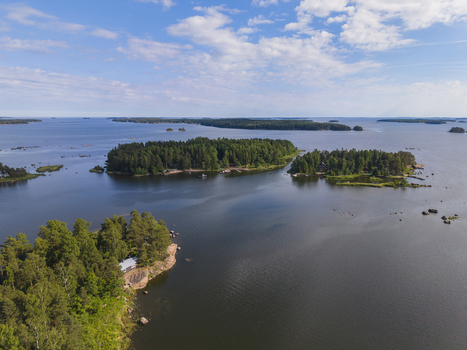 Aerial view of forested islands and rocky coastline in the Gulf of Finland with calm blue waters and scattered islets under a bright sky in Hamina Kymenlaakso Finland. Aerial view of forested islands and rocky coastline in the Gulf of Finland with calm blue waters and scattered islets under a bright sky in Hamina Kymenlaakso Finland.
