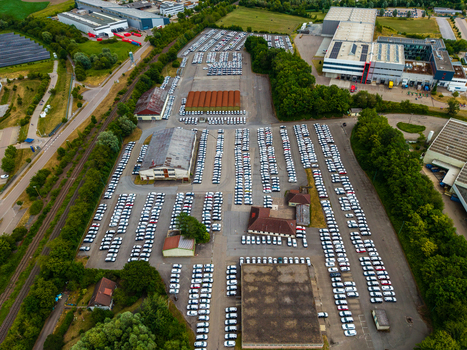 Aerial view of Serways Raststatte Hohenlohe Sud with a large parking lot filled with cars industrial buildings green trees and railway tracks in Neuenstein Baden Wurttemberg Germany. Aerial view of Serways Raststatte Hohenlohe Sud with a large parking lot filled with cars industrial buildings green trees and railway tracks in Neuenstein Baden Wurttemberg Germany.