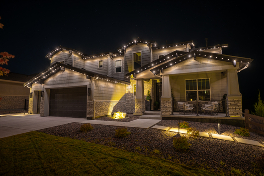 View of a modern suburban house at night illuminated by decorative LED roofline lighting and landscape lights in Aurora Colorado United States. View of a modern suburban house at night illuminated by decorative LED roofline lighting and landscape lights in Aurora Colorado United States.