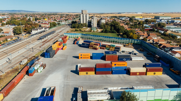 Indjija Vojvodina Serbia 24 August 2026 Aerial view of a container terminal with colorful shipping containers railway tracks and industrial silos under a clear blue sky.