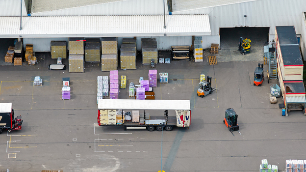 Aerial view of the Boekelermeer industrial site with forklifts operating near a loading dock and various pallets of goods stored outside in Alkmaar Noord Holland Netherlands.
