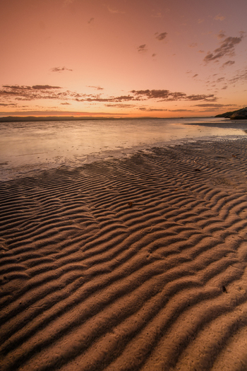 View of the ripple patterns on the sand at Quaranup Beach during a warm sunset in Vancouver Peninsula Western Australia Australia. View of the ripple patterns on the sand at Quaranup Beach during a warm sunset in Vancouver Peninsula Western Australia Australia.