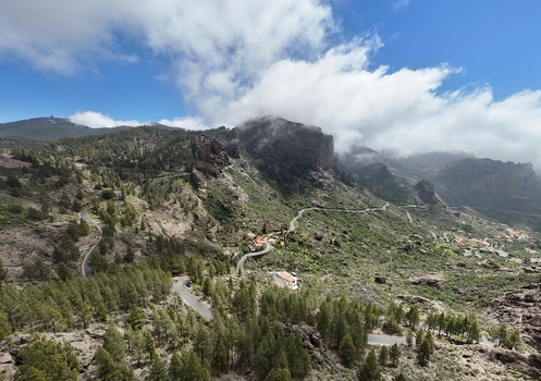 Aerial view of Roque Nublo s rugged peaks shrouded in mist contrasting with the lush green valleys and winding roads below La Culata Canarias Spain. Aerial view of Roque Nublo s rugged peaks shrouded in mist contrasting with the lush green valleys and winding roads below La Culata Canarias Spain.