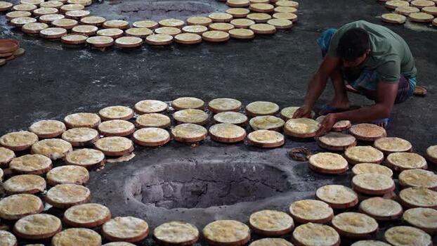 View of a man arranging traditional yogurt pots in Bogura Bangladesh. View of a man arranging traditional yogurt pots in Bogura Bangladesh.