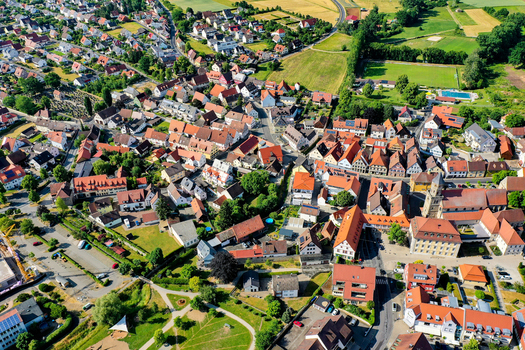 Aerial view of the historic town center with red roofed houses a church tower and green fields in Neunkirchen am Brand Bavaria Germany. Aerial view of the historic town center with red roofed houses a church tower and green fields in Neunkirchen am Brand Bavaria Germany.