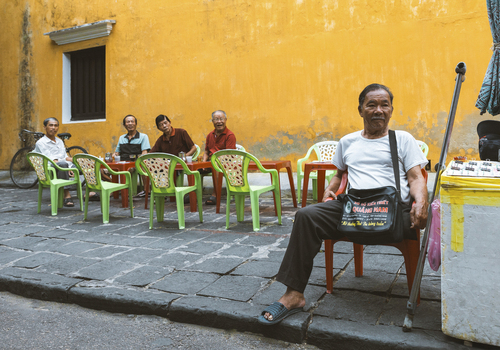 Thanh Pho Hoi An Vietnam 02 August 2023 View of people socializing in front of a vibrant yellow wall with outdoor seating Hoi An Vietnam.