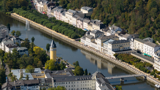 Aerial view of the Lahn river flowing through Bad Ems featuring the Kurhaus a yellow tower and tree lined promenades in Bad Ems Rhineland Palatinate Germany. Aerial view of the Lahn river flowing through Bad Ems featuring the Kurhaus a yellow tower and tree lined promenades in Bad Ems Rhineland Palatinate Germany.