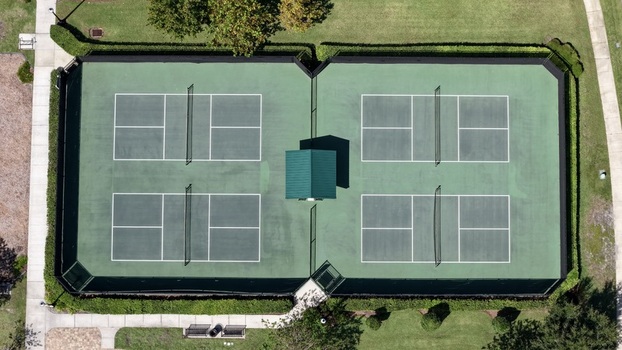 Aerial view of tennis courts at Windward Ranch Boulevard featuring green surfaces nets and surrounding landscaping in St. Johns County Florida United States. Aerial view of tennis courts at Windward Ranch Boulevard featuring green surfaces nets and surrounding landscaping in St. Johns County Florida United States.