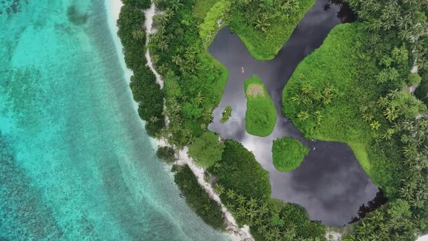 Aerial view of a tropical island with a dark lagoon and coral reef Maldives. Aerial view of a tropical island with a dark lagoon and coral reef Maldives.
