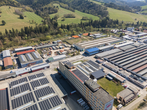 Aerial view of an industrial complex with solar panels on rooftops and surrounding green hills in Nizna Zilina Region Slovakia. Aerial view of an industrial complex with solar panels on rooftops and surrounding green hills in Nizna Zilina Region Slovakia.