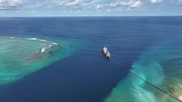 Aerial view of a dredger ship near a coral reef Maldives.