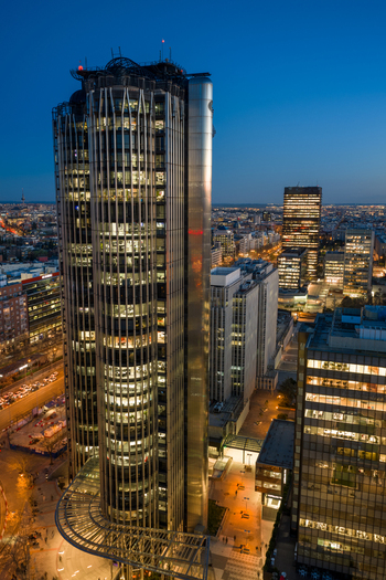 Aerial view of the iconic Torres KIO skyscrapers illuminated at twilight featuring their inclined architecture overlooking the city skyline of Madrid Community of Madrid Spain.