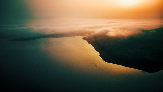 Aerial view of Owala Dam at sunset with mist covering the water surface and surrounding landscape in Osogbo Osun Nigeria. Aerial view of Owala Dam at sunset with mist covering the water surface and surrounding landscape in Osogbo Osun Nigeria.