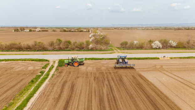 Aerial view of tractors working the land in a rural field a testament to the agricultural heartland Sremska Mitrovica Vojvodina Serbia. Aerial view of tractors working the land in a rural field a testament to the agricultural heartland Sremska Mitrovica Vojvodina Serbia.