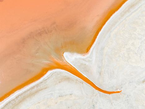 Aerial view of the abstract patterns of a salt lake with vibrant orange water and white salt crust in the Mallee region Woorinen North Victoria Australia. Aerial view of the abstract patterns of a salt lake with vibrant orange water and white salt crust in the Mallee region Woorinen North Victoria Australia.