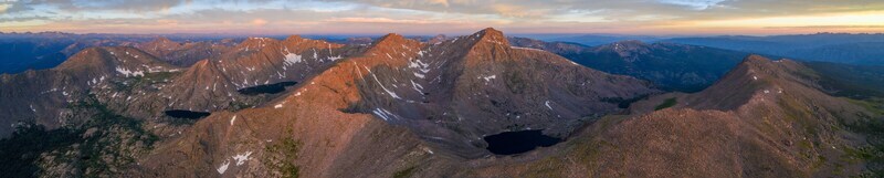 Aerial view of Mount of the Holy Cross in the Sawatch Range at sunset featuring rugged rocky peaks patches of snow alpine lakes and dramatic golden light in Vail Colorado United States. Aerial view of Mount of the Holy Cross in the Sawatch Range at sunset featuring rugged rocky peaks patches of snow alpine lakes and dramatic golden light in Vail Colorado United States.