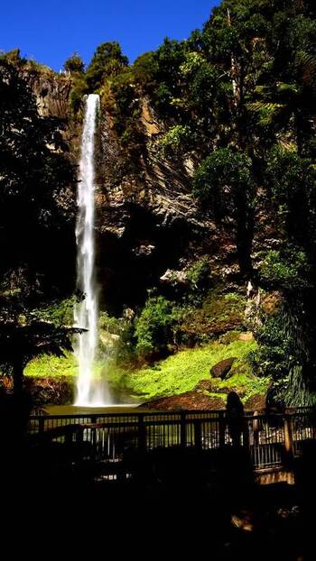 View of a tall waterfall and viewing platform New Zealand.