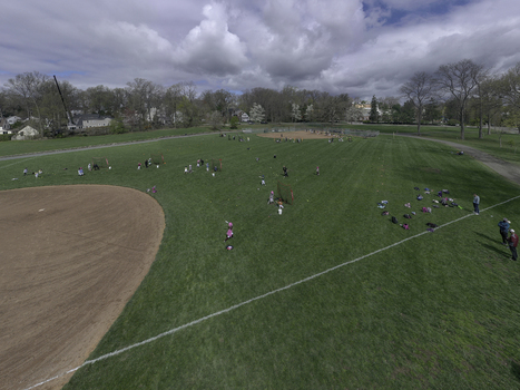 Aerial view of a baseball field in a park with players practicing on the grass and dirt infields surrounded by trees under a cloudy sky in Summit New Jersey United States. Aerial view of a baseball field in a park with players practicing on the grass and dirt infields surrounded by trees under a cloudy sky in Summit New Jersey United States.