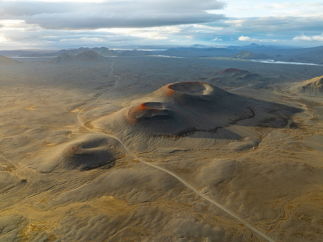 Aerial view of Landmannalaugar volcanic craters surrounded by a vast barren rocky landscape and a winding dirt road in Rangarthing ytra Iceland. Aerial view of Landmannalaugar volcanic craters surrounded by a vast barren rocky landscape and a winding dirt road in Rangarthing ytra Iceland.